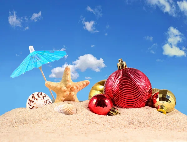 Рождественские украшения, ракушки и морские звезды на песке — стоковое фото