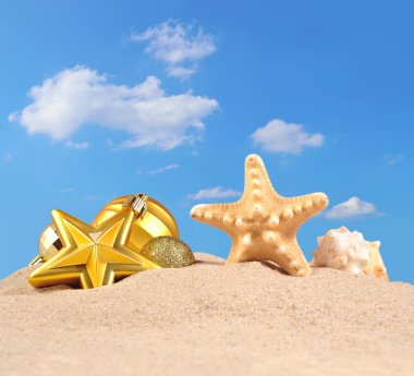 Noel süsleri, kabukları ve denizyıldızı plaj kum üzerinde