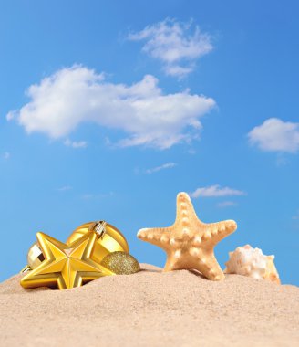 Noel süsleri, kabukları ve denizyıldızı plaj kum üzerinde