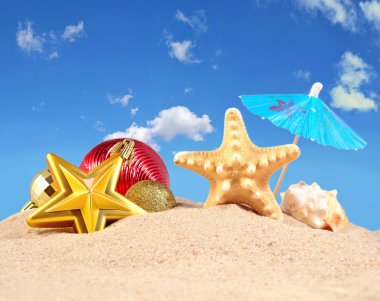 Noel süsleri, kabukları ve denizyıldızı plaj kum üzerinde