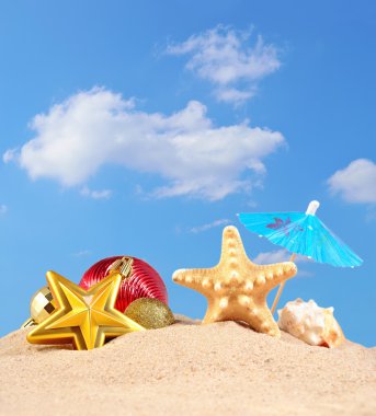 Noel süsleri, kabukları ve denizyıldızı plaj kum üzerinde