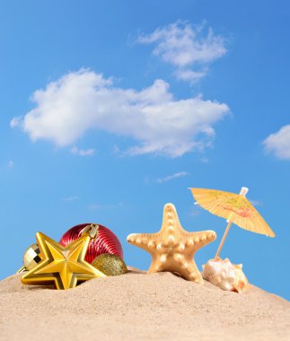 Noel süsleri, kabukları ve denizyıldızı plaj kum üzerinde