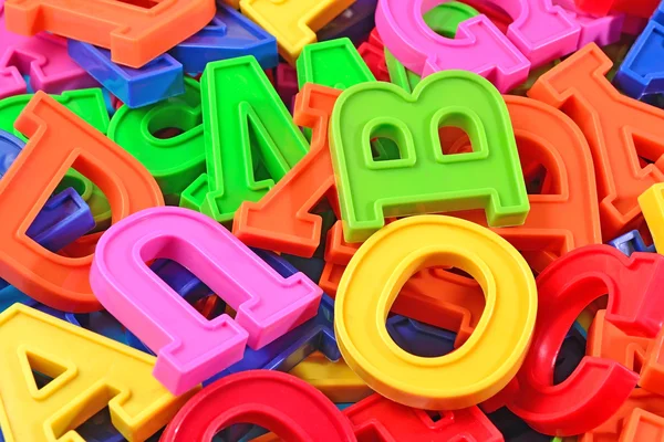 Heap de plástico letras alfabeto coloridas fechar — Fotografia de Stock
