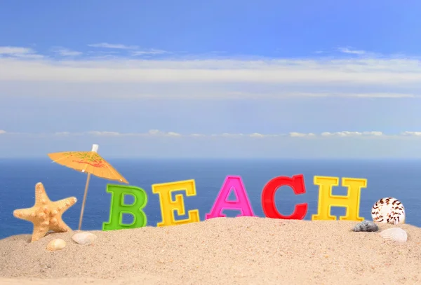 Letras de playa en una arena de playa — Foto de Stock