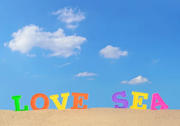 Szerelmes a tengerparton homok tengeri levelek — Stock Fotó