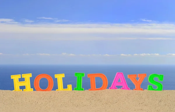 Holidays letters on a beach sand — Stock Photo, Image