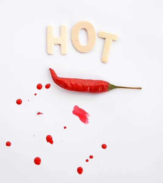 Red chili on white background with text hot. — Stock Photo, Image