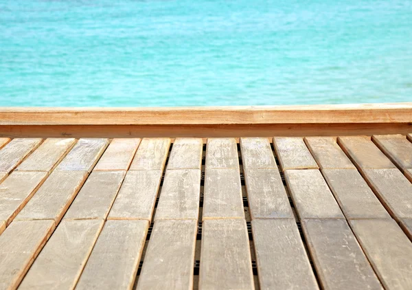 Pavimento in legno con mare e cielo sfondo sfocato — Foto Stock