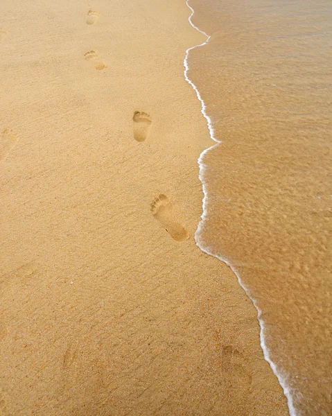 人类留下脚印在沙滩上的沙子背景上 — 图库照片