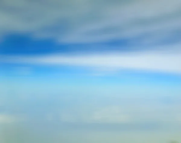 Verschwommener blauer Himmel und Wolken, die durch das Fenster des Flugzeugs schauen — Stockfoto