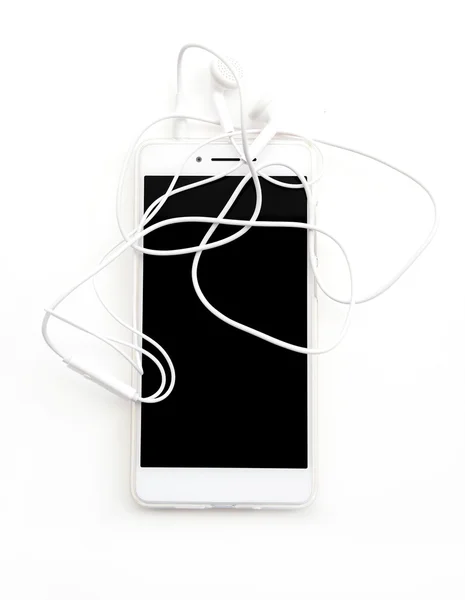 Witte smartphone met koptelefoon op wit. — Stockfoto
