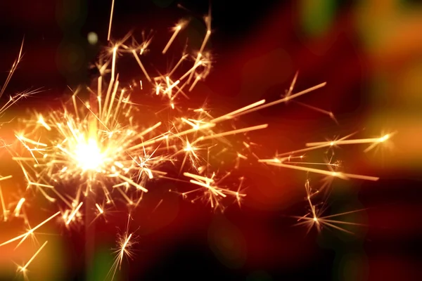 Christmas sparkler in haze with red light — Stock Photo, Image