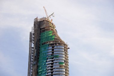 Mavi gökyüzüne karşı vinç ve inşaat alanı