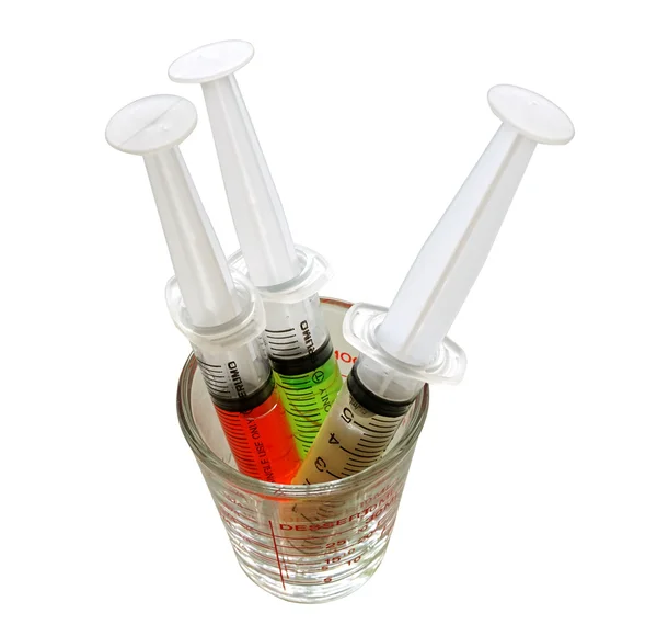 Medizinische Werkzeugspritze mit farbigen Flüssigkeiten isoliert auf weiß — Stockfoto