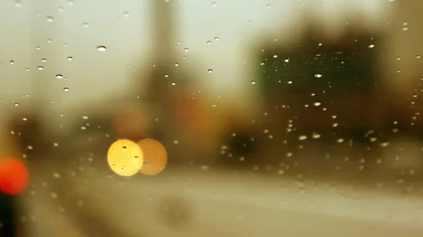 Drop auf ein Glasfenster und eine verschwommene Landschaft auf dem Hintergrund — Stockfoto