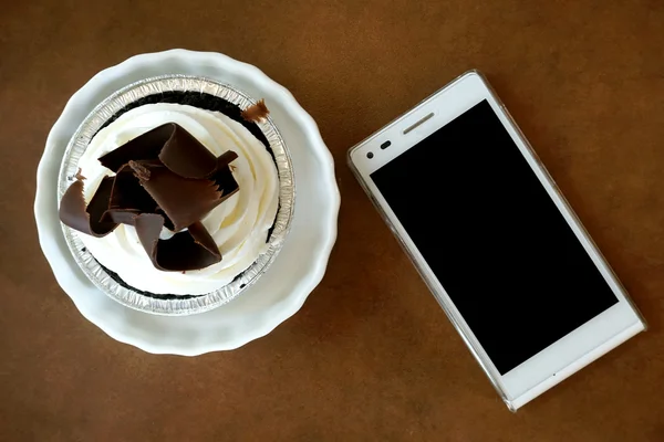 Torta de Banoffee com celular na mesa — Fotografia de Stock
