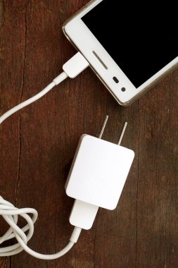 Beyaz akıllı telefon ile eski ahşap masa üzerinde izole perde