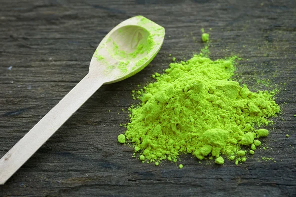 Green paint powder on wooden table — Stock Photo, Image