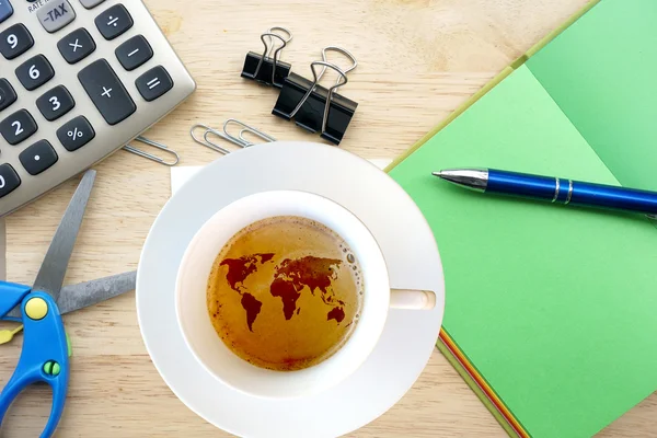 Warme koffie met wereldkaart en kantoorbenodigdheden — Stockfoto