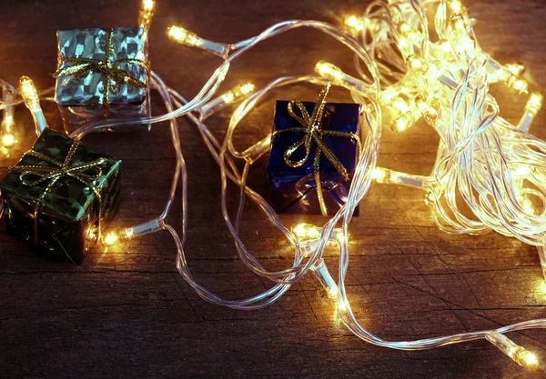 Set of Christmas gift boxes with light on wood. — Stock Photo, Image