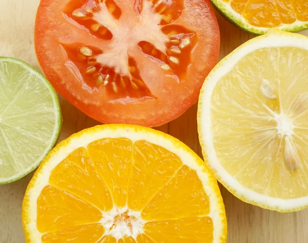 Grupo de frutas cítricas en rodajas de medio corte Limón fresco, lima verde, naranja y tomate rojo — Foto de Stock