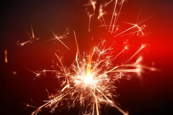 Sparkler fire on red background — Stock Photo, Image