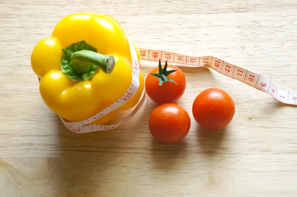 Dieta vegetal. Sino de pimentão amarelo com fita métrica e tomates (conceito de dieta ) — Fotografia de Stock