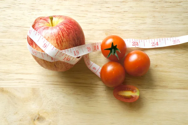 Envoltura de manzana roja y tomates con cinta métrica (concepto de dieta) ) —  Fotos de Stock