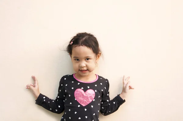 Zafer hareketi ile iki eli gösteren küçük bir kız — Stok fotoğraf