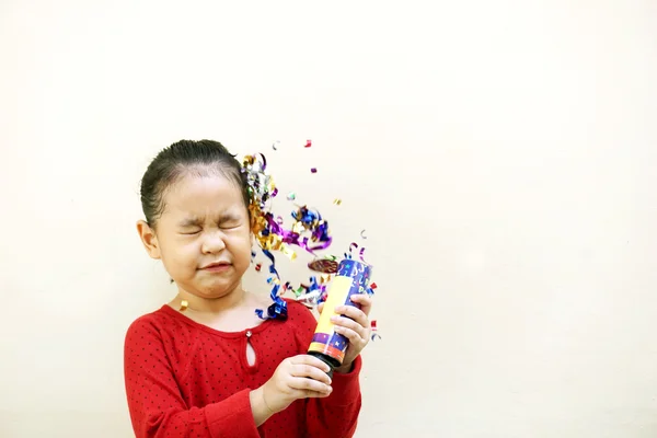 Menina feliz comemorando com festa popper no fundo branco isolado — Fotografia de Stock