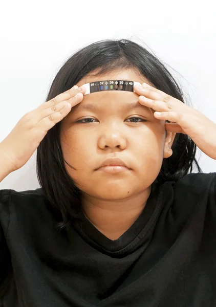 Doente menina segurando almofada termômetro na testa — Fotografia de Stock