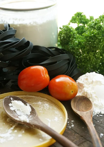 Pasta italiana tagliatelle con tomate sobre fondo de madera — Foto de Stock