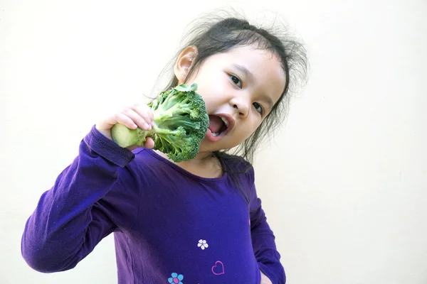 Niña comiendo brócoli - comida saludable —  Fotos de Stock