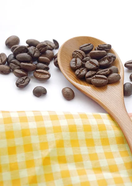 Grano de café tostado marrón con cuchara de té sobre fondo blanco — Foto de Stock