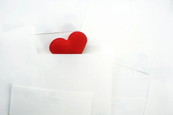 Красное сердце скрыто на белом бумажном фоне — стоковое фото