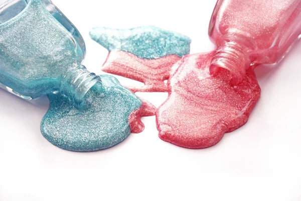 Blauer und pinkfarbener Nagellack auf weißem Hintergrund — Stockfoto