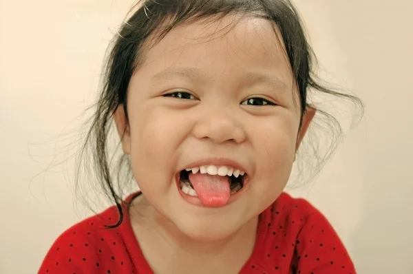 Usměvavá holčička ukazuje jazyk — Stock fotografie