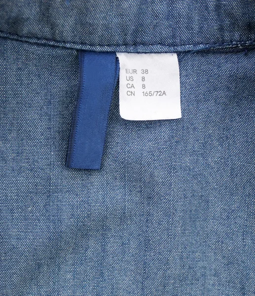 Etiqueta de talla en camisa jeans —  Fotos de Stock