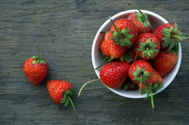 Eski ahşap arka planda taze çilekler.