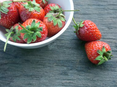 Eski ahşap arka planda taze çilekler.