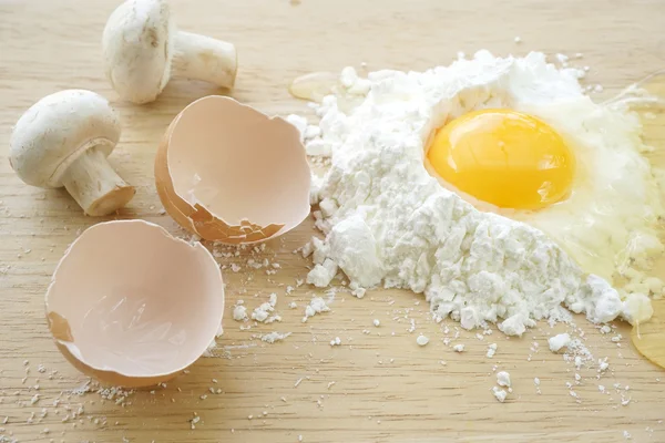 Harina blanca y huevos sobre fondo de madera — Foto de Stock