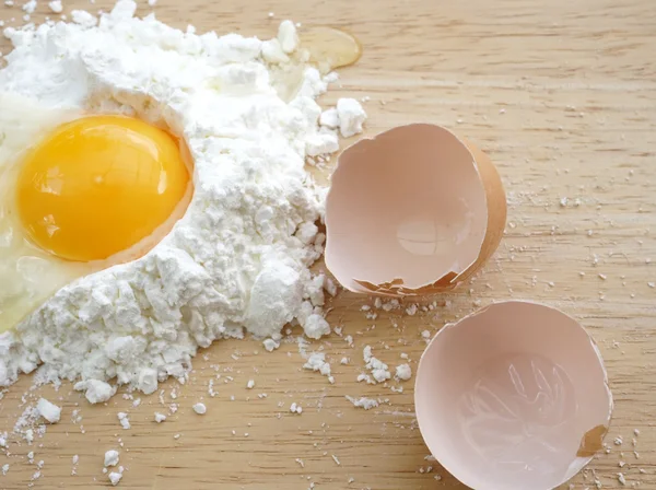 Harina blanca y huevos sobre fondo de madera — Foto de Stock