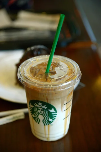 Bangkok, Thajsko-březen 7: Sklo Starbucks Coffee Latte nápoje podávané na dřevo stolu v prodejně Starbucks v devět, Bangkok, Thajsko. — Stock fotografie