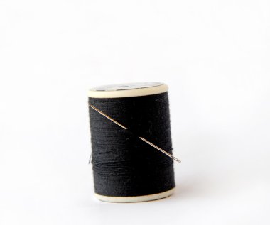 beyaz zemin üzerinde bir iğne closeup ile iplik makarası