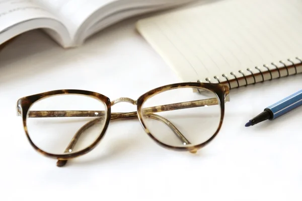 Notebook com óculos e caneta na mesa, close-up — Fotografia de Stock