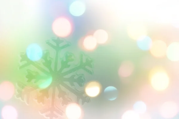 Copo de nieve con Bokeh multicolor y estrellas en el fondo azul —  Fotos de Stock