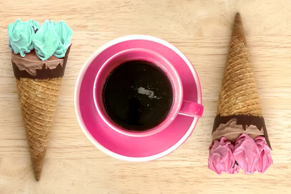 Cones de sorvete e xícara de café quente no fundo vintage de madeira — Fotografia de Stock