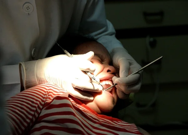 Стоматолог вивчає дитину зі спеціалізованими інструментами — стокове фото