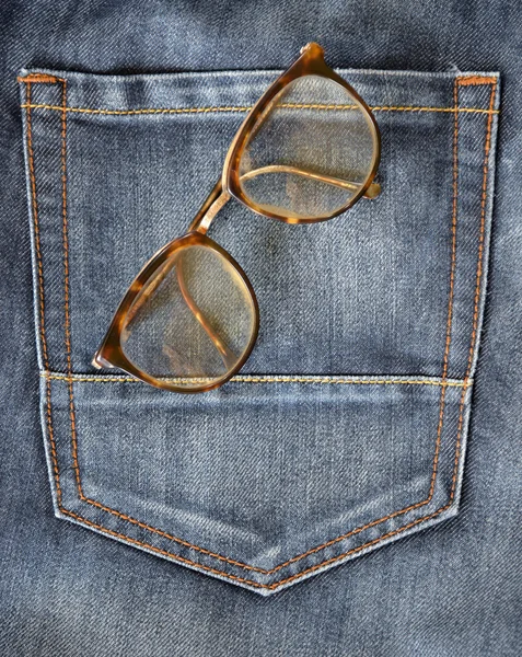 Blå jeans ficka närbild med glasögon — Stockfoto