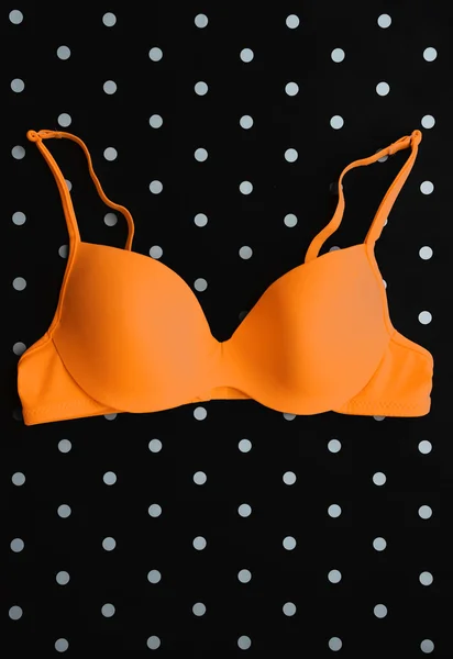 Soutien-gorge orange sur fond à pois noir et blanc — Photo